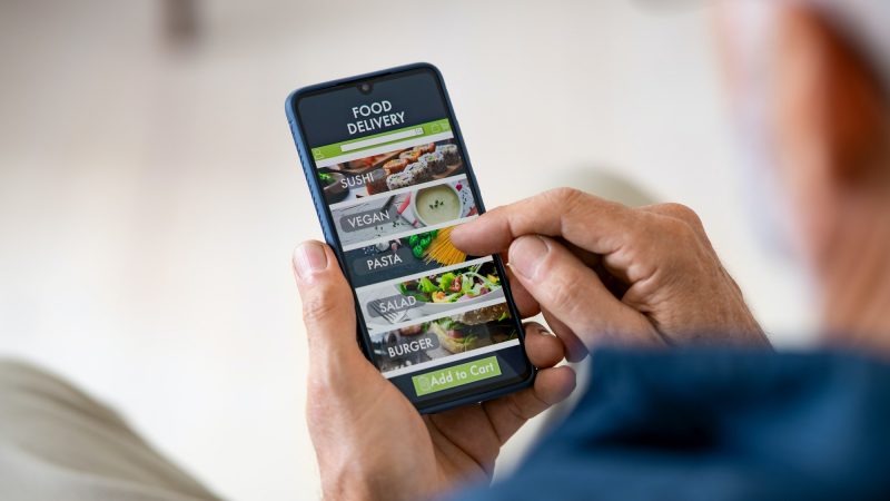 man using mobile app to order delivery food
